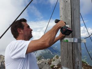 Miha Krišelj namešča novo ploščico na križ