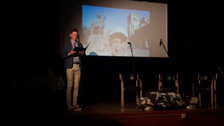 Voditelj Jernej Volčjak bere obrazložitev za priznanje dr. Vladimirju Žumru